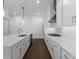 Modern kitchen with stainless steel appliances, island, white cabinetry, and wood floors at 2140 Parkside Ln, Roswell, GA 30076