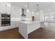 Modern kitchen featuring white cabinets, stainless steel appliances, a large island, and hardwood floors at 2140 Parkside Ln, Roswell, GA 30076