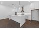 Bright kitchen features a large island, stainless steel appliances, and modern pendant lighting at 2140 Parkside Ln, Roswell, GA 30076