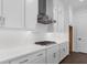 Close-up view of a modern kitchen with stainless steel range hood and white cabinets at 2140 Parkside Ln, Roswell, GA 30076