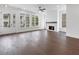 Bright living room showcasing hardwood floors, a cozy fireplace, and large windows offering a view of the outdoors at 2140 Parkside Ln, Roswell, GA 30076