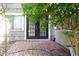 The back patio with brick flooring features access to the home via French doors and is surrounded by lush greenery at 3938 Landress Way, Lawrenceville, GA 30044