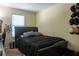 A bedroom with a black upholstered bed, a window with blinds, and wall decorations at 3938 Landress Way, Lawrenceville, GA 30044