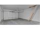 Spacious garage with ladder access to overhead storage and roll-up door at 2040 Ripple Park Bnd, Canton, GA 30114