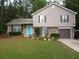Charming two-story home with a well-manicured lawn, brick accents, and a vibrant turquoise front door at 4678 Browns Mill Ferry Rd, Lithonia, GA 30038