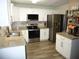 Modern kitchen features stainless steel appliances, white cabinetry, granite counters, and stylish wood floors at 4678 Browns Mill Ferry Rd, Lithonia, GA 30038
