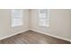 This bedroom is a cozy space with wood-look floors and natural light from two windows at 2283 Noahs Ark Rd, Jonesboro, GA 30236