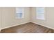 Well-lit bedroom with neutral walls, two windows, and durable hardwood floors at 2283 Noahs Ark Rd, Jonesboro, GA 30236