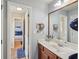 Well-lit bathroom features a vanity, large mirror, and view into a bedroom at 4740 Arbor Meadows Dr, Cumming, GA 30040