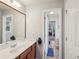 Well-lit bathroom featuring a large mirror, vanity with storage, and an open doorway at 4740 Arbor Meadows Dr, Cumming, GA 30040