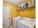 Bright laundry room featuring a washer, dryer, storage shelf, and a door at 4740 Arbor Meadows Dr, Cumming, GA 30040
