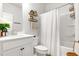 Bright bathroom featuring a toilet, shower with curtain, vanity, and wood accents at 4758 Sultana Way, Atlanta, GA 30331