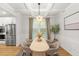 Bright and airy dining room showcasing a table set for four, modern light fixture, and stainless steel appliances at 4758 Sultana Way, Atlanta, GA 30331