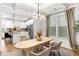 Open-concept dining area with modern light fixture, kitchen in the background, and large windows providing natural light at 4758 Sultana Way, Atlanta, GA 30331