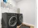 Modern laundry room with black washer and dryer, white walls, and practical storage solutions at 4758 Sultana Way, Atlanta, GA 30331