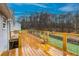 A wooden deck with nice landscaping with a metal railing at 218 Pine Needle Trl, Villa Rica, GA 30180