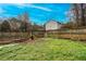 A fenced backyard, with green grass and the neighbors house in the background at 218 Pine Needle Trl, Villa Rica, GA 30180