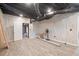 Finished basement with wood-style vinyl flooring and ceiling beams at 218 Pine Needle Trl, Villa Rica, GA 30180