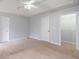 Spacious main bedroom featuring neutral paint, plush carpet, and ceiling fan and a walk in closet at 218 Pine Needle Trl, Villa Rica, GA 30180