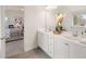 Bright bathroom featuring double vanity sinks, white cabinets, and a mirror with decor at 2201 Cormac St, East Point, GA 30344