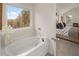 Relaxing bathroom featuring a soaking tub and a window with natural light and a view of trees at 2201 Cormac St, East Point, GA 30344