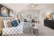Well-lit main bedroom featuring a large bed, carpet flooring, and a dresser with a decorative round mirror at 2201 Cormac St, East Point, GA 30344