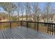 A spacious back deck with stained wood overlooking a wooded backyard and neighboring houses at 4340 Boxwood Trl, Ellenwood, GA 30294