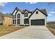 Classic two-story home boasting a large driveway, well-maintained lawn, and elegant architectural details with black trim at 4340 Boxwood Trl, Ellenwood, GA 30294