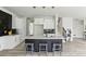 A modern kitchen featuring white cabinets, a black tile backsplash, quartz countertops and a center island with bar stool seating at 4340 Boxwood Trl, Ellenwood, GA 30294