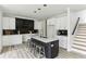 A modern kitchen featuring white cabinets, a black tile backsplash, quartz countertops and a center island with bar stool seating at 4340 Boxwood Trl, Ellenwood, GA 30294