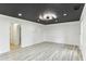 Spacious living room with modern lighting, light wood floors, and an adjacent doorway at 4340 Boxwood Trl, Ellenwood, GA 30294