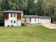 Split-level home with white siding, dark roof, attached garage and front yard at 1173 Mill Ridge Dr, Lawrenceville, GA 30045