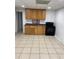 Kitchen featuring tile floor, wooden cabinets, and black stove at 1173 Mill Ridge Dr, Lawrenceville, GA 30045