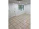 Bright living room with neutral tile flooring, a window letting in natural light, and a white front door at 1173 Mill Ridge Dr, Lawrenceville, GA 30045