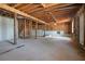 Open unfinished basement featuring exposed wood beams and concrete floor at 613 Woodstone Rd, Lithonia, GA 30058