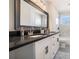 Bathroom with double sink vanity, granite counters, framed mirror, and decorative rug at 613 Woodstone Rd, Lithonia, GA 30058