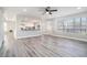 Open concept living room with ceiling fan and an adjacent view of the modern kitchen at 613 Woodstone Rd, Lithonia, GA 30058