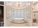 Soaking tub next to stained-glass windows in luxurious primary bathroom at 8480 St Marlo Fairway, Duluth, GA 30097