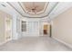 Spacious bedroom featuring tray ceiling, ceiling fan, and custom built-in shelving and cabinets at 8480 St Marlo Fairway, Duluth, GA 30097