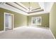 Green bedroom with a tray ceiling and ceiling fan showing a view of the window and bathroom at 8480 St Marlo Fairway, Duluth, GA 30097