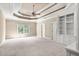 Bedroom with a tray ceiling and a view of the window and built in shelving and cabinets at 8480 St Marlo Fairway, Duluth, GA 30097