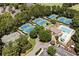 Aerial view of a community featuring multiple tennis courts, a pool and recreation center, and mature trees at 8480 St Marlo Fairway, Duluth, GA 30097