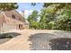Brick driveway leading to a three car garage with a beautiful green lawn surrounded by mature trees at 8480 St Marlo Fairway, Duluth, GA 30097