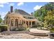 Expansive home exterior featuring stone accents, arched porticos, and manicured landscaping at 8480 St Marlo Fairway, Duluth, GA 30097