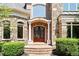 Detailed front entrance showcasing a brick facade, custom wood doors, and manicured shrubbery at 8480 St Marlo Fairway, Duluth, GA 30097