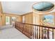 Upstairs hallway with ornate trim, railing and chandelier showing views of the entry foyer at 8480 St Marlo Fairway, Duluth, GA 30097