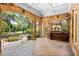 Covered stone patio with an outdoor kitchen and iron railing overlooking manicured lawn at 8480 St Marlo Fairway, Duluth, GA 30097
