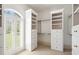 Bright walk-in closet featuring built-in shelving, drawers, and natural light from a windowed door at 8480 St Marlo Fairway, Duluth, GA 30097
