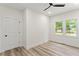 Bright bedroom features neutral walls, wood-look floors, three windows, white trim, and a ceiling fan at 1400 Bouldercrest Rd, Atlanta, GA 30316