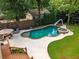 An aerial view showcasing a backyard oasis with a pool, lush landscaping, and a cozy outdoor dining area at 1518 Cambridge Ave, Atlanta, GA 30337